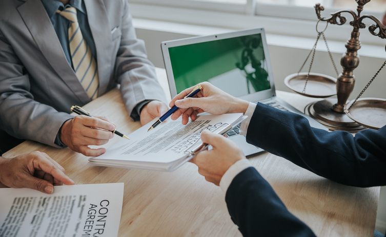 Businessmen and lawyers discuss contract documents